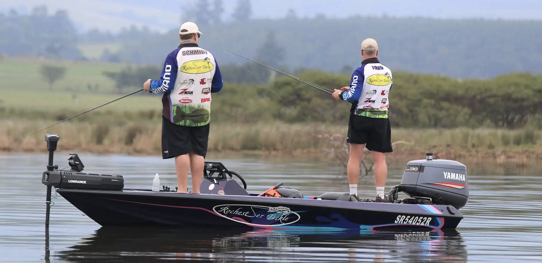 Two anglers casting from the Rochester boat past drowned trees at Albert Falls