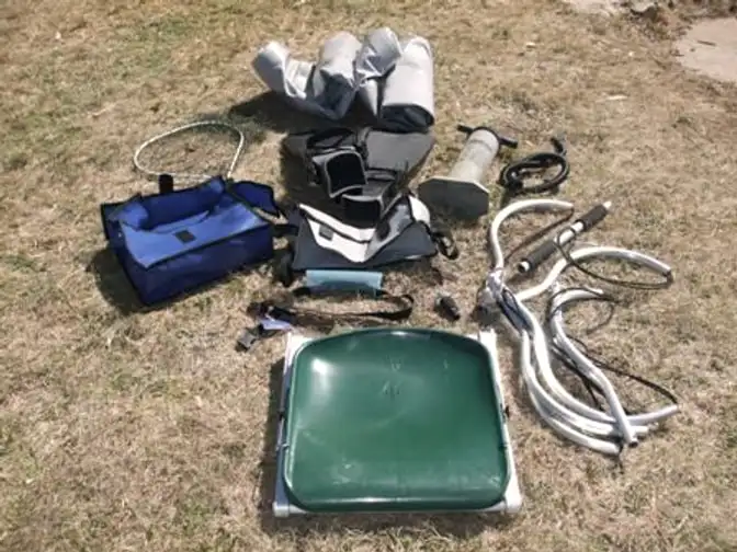 The Waterbug laid out on grass: pontoons, seat, rod holder, stripping tray and bags