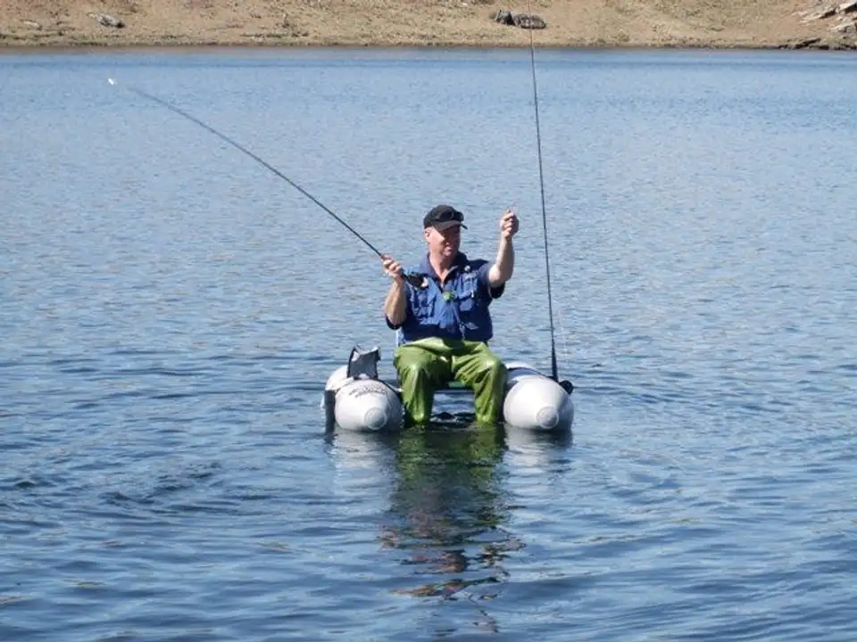 An angler fly fishing from a Waterbug kick boat on a dam