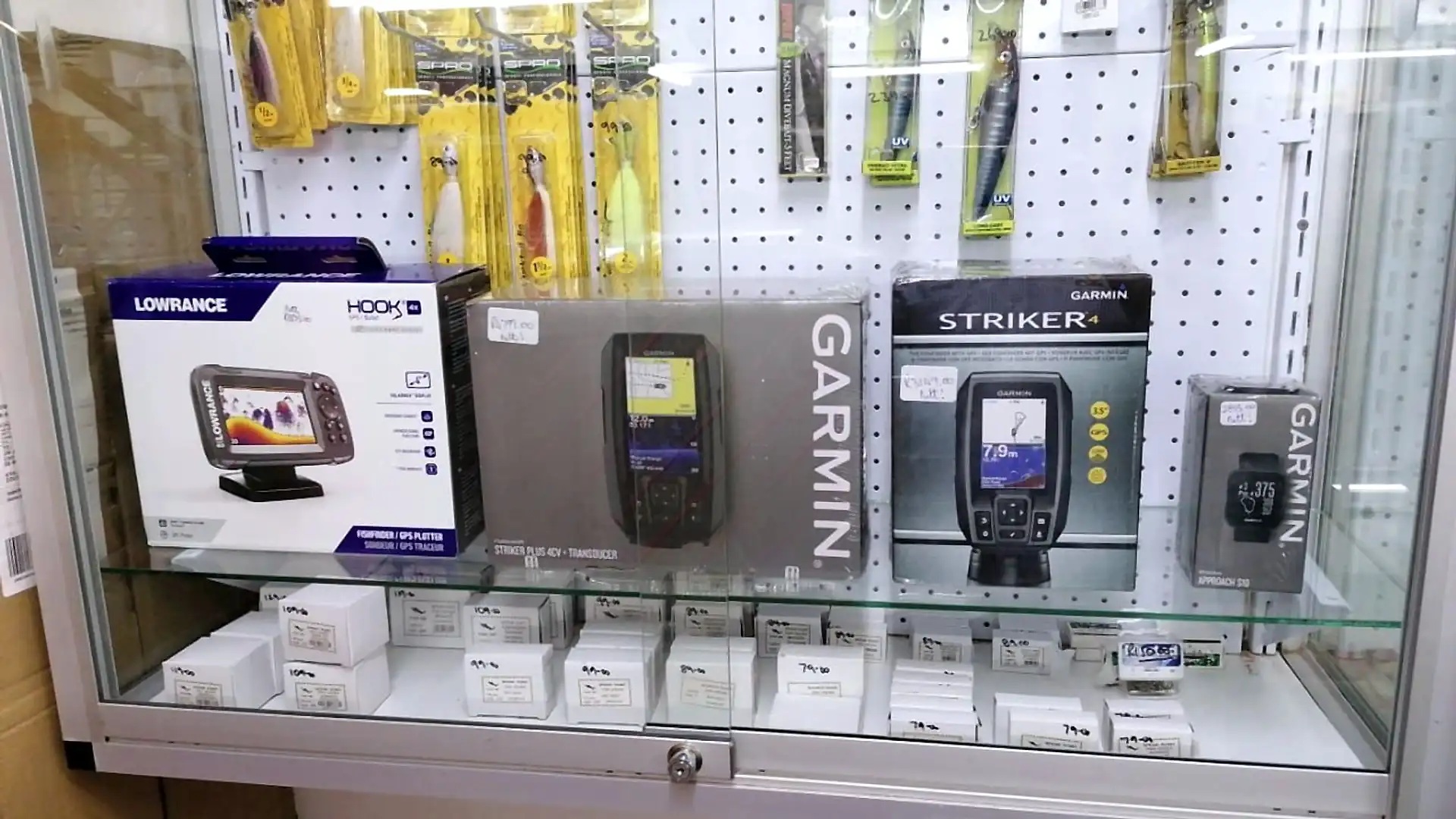 Lowrance and Garmin fish finders in a glass display cabinet