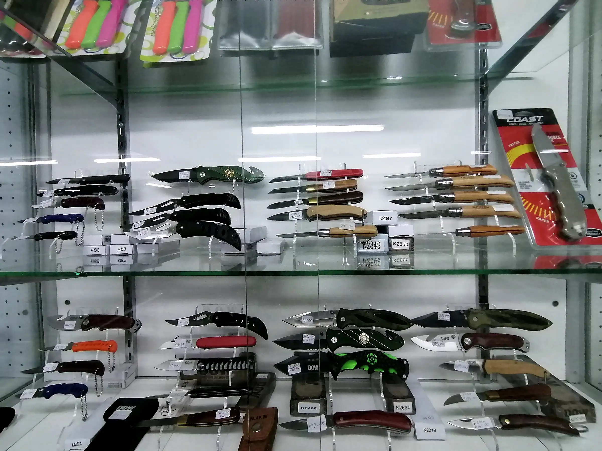 A glass cabinet of folding and fixed-blade knives