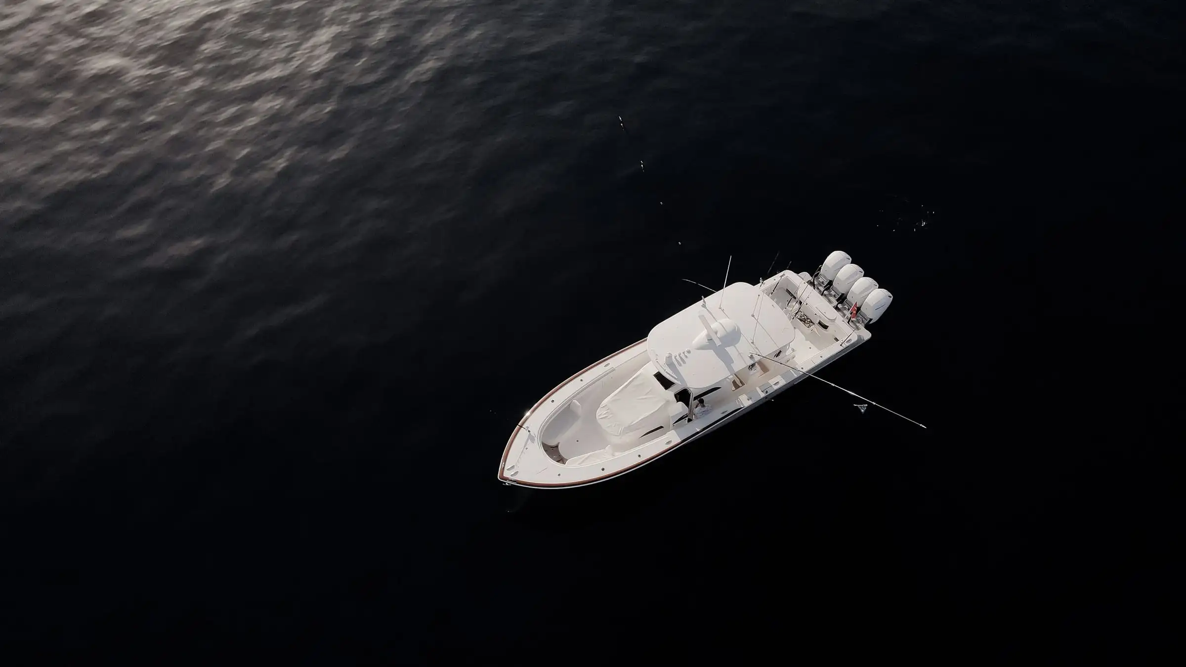 A small fishing boat on dark open water, seen from above