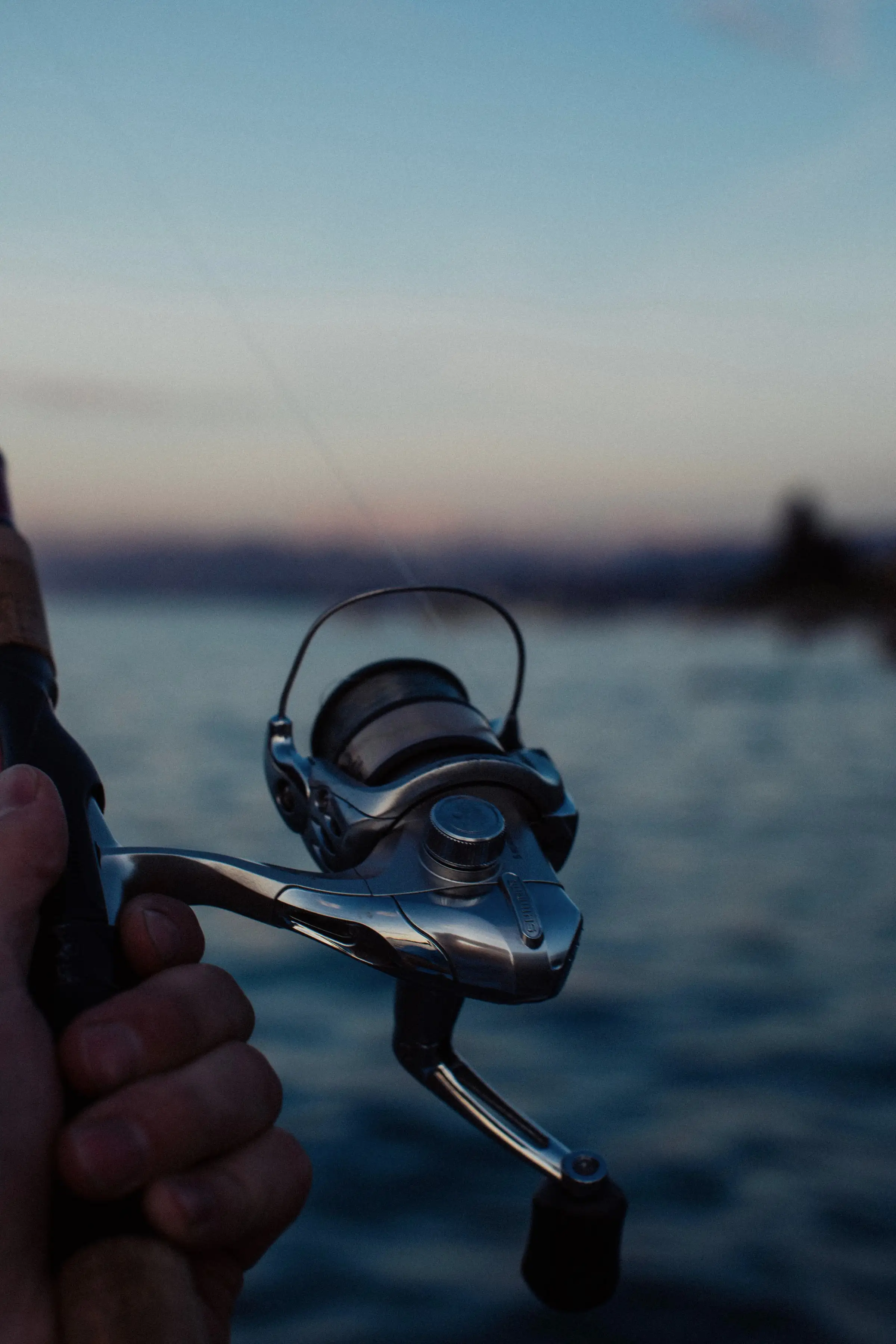 A spinning reel on a rod, close up, at dawn