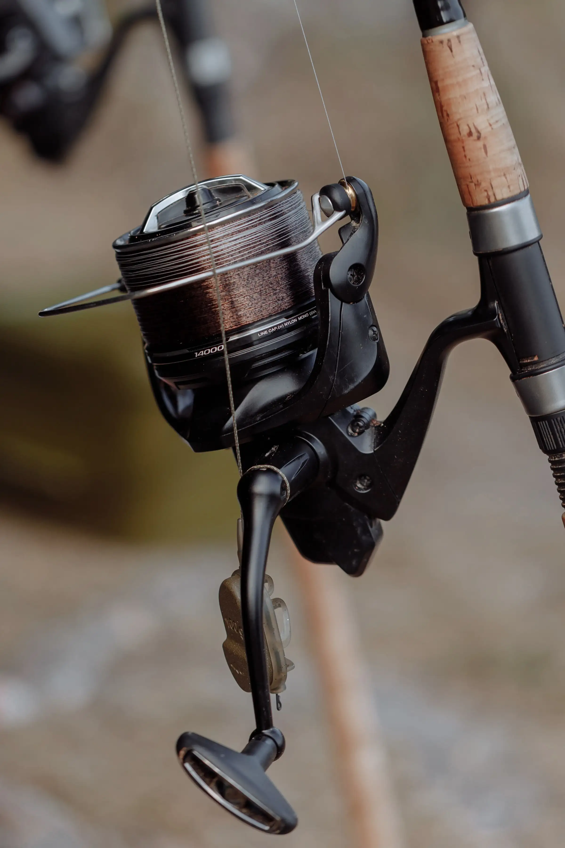 A spinning reel on a cork-handled rod, close up