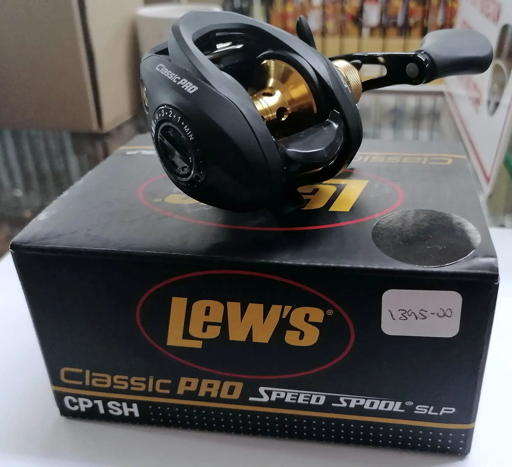 A baitcasting reel on its box on the shop counter