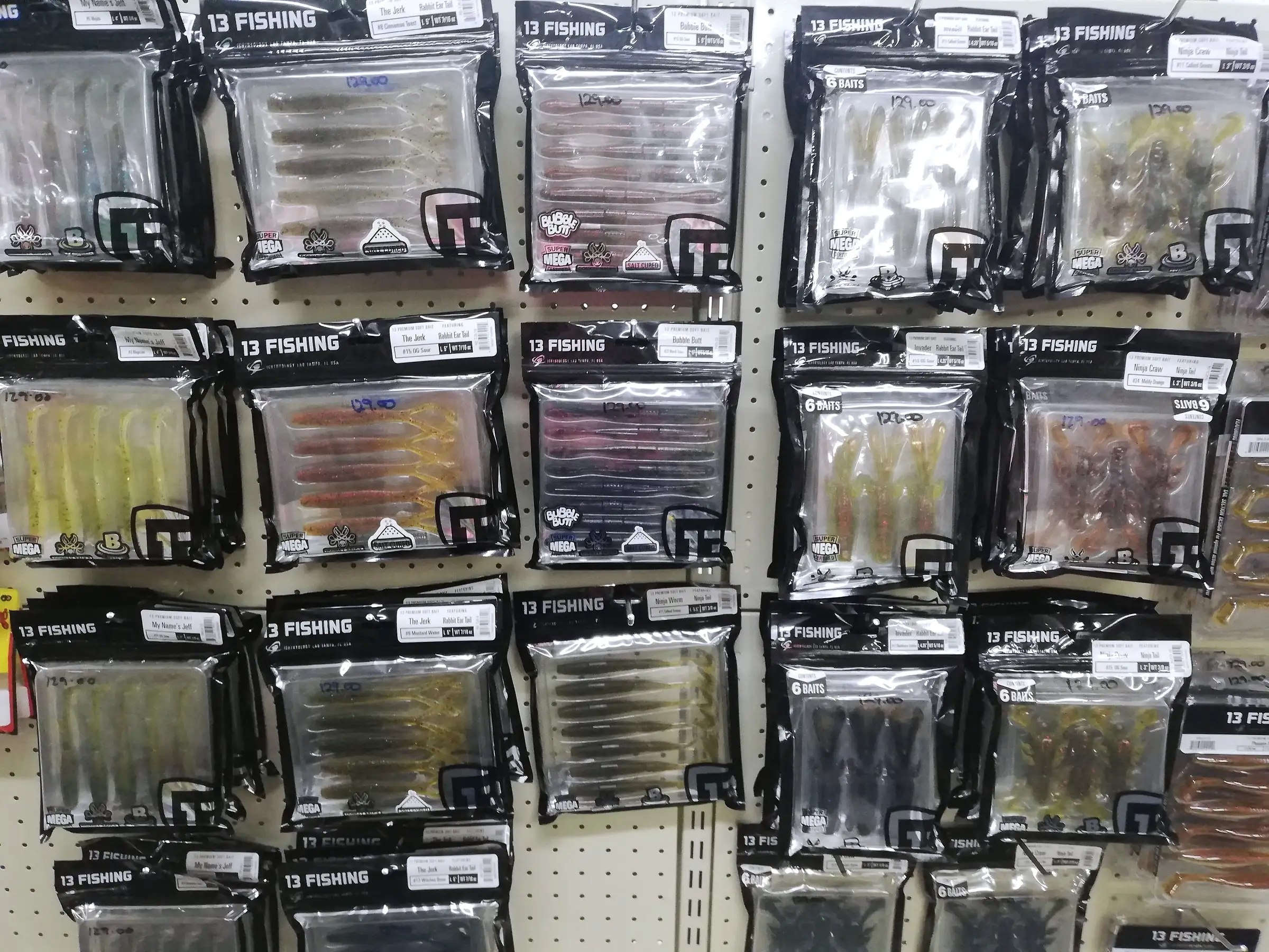 Packs of 13 Fishing soft plastic swimbaits hanging on a pegboard wall